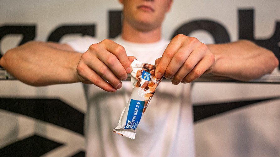 En mand er ved at bne en Core 2.0 Proteinbar.